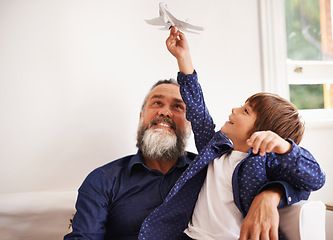 Image showing Grandpa, kid and playing with toy airplane in home, love and bonding together on vacation in living room. Happy family, boy and grandfather with jet game in lounge, relax and care on school holiday