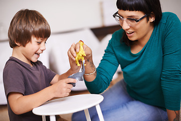 Image showing Mother, son and play with toy, dinosaur and fun in home or house with joy. Woman, child and happiness with smile, youth and childhood development for future growth and bonding or single parent care