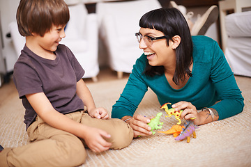 Image showing Mother, kid and toy with dinosaur, floor and play for joy or fun at family home or house. Woman, child and bedroom with bonding, childhood and future development or growth for happy care together