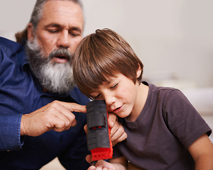 Image showing Grandfather, toy and train with boy child, playing and bonding in family home. Grandpa, young kid and childhood development with games and fun, quality time and love with elderly retired man