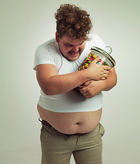 Image showing Candy, jar and man in studio for sweets, luxury snacks, and dessert in container. Comic, hungry and food, isolated and plus size male person with glass for unhealthy diet on mockup background