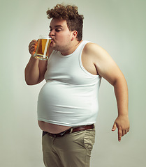 Image showing Chubby, weight gain and beer for man in studio with alcohol for unhealthy habit, plus size and humor. Overweight person with glass in hand and drinking with fat stomach for comedy, joke and funny