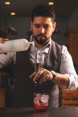 Image showing Expert bartender pouring a cocktail