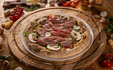 Image showing Delicious pizza with prosciutto and mushrooms