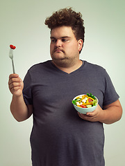 Image showing Unhappy, man and salad in studio for weight loss, healthy food and organic nutrition for wellness. Male person, plus size and disgust with meal for vitamin c, detox or lifestyle change for diet