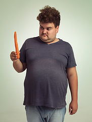 Image showing Man, vegetables and carrot in studio with thinking for healthy snack, detox and vitamin c for wellness. Plus size, male person and unhappy with organic food for nutrition, lifestyle and diet
