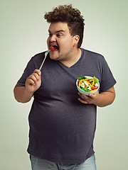 Image showing Studio, plus size and man with eating salad for weight loss, healthy diet and vitamin c benefits. Fork, tomato and male person with organic food for detox, nutrition or commitment to lifestyle change