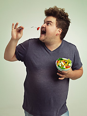 Image showing Studio, man and eating salad for weight loss, healthy diet and lifestyle benefits for wellness. Plus size, male person and fork with organic food for nutrition, vitamin c and hungry with lunch meal