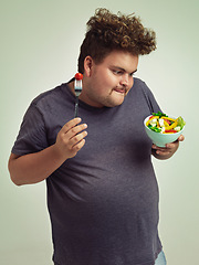 Image showing Happy, plus size and man with salad in studio for healthy diet, natural nutrition and weight loss. Male person, organic food and tomato on fork with thinking for vitamin c, detox or vegan change