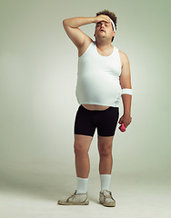 Image showing Plus size, tired man and dumbbells for exercise, training or workout in studio isolated on a white background mockup space. Body, fatigue and person on break with weights for muscle, fitness or rest