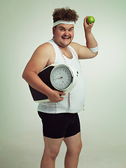 Image showing Scale, happy man and portrait with apple for fitness, health or nutrition isolated on gray studio background mockup. Plus size, fruit or diet for weight loss of body of male person with tape measure