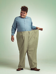 Image showing Happy man, portrait and plus size with pants for weight loss, measurement or waist on a studio background. Male person with smile for healthy diet, obesity or overweight clothing on mockup space