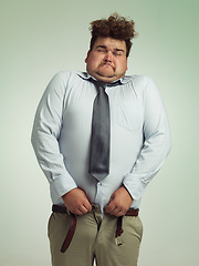 Image showing Man, pants and plus size with big waist in obesity, overweigh or measurement on a studio background. Young male person struggling to fit on clothing with body fat or chubby stomach on mockup space