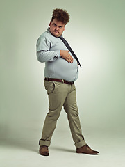 Image showing Business man, portrait and plus size with stomach gesture and silly in a studio with funny joke. Goofy, employee and office fashion with fun and work clothing with green background and humor