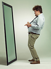 Image showing Man, mirror and plus size with reflection for confidence in body fat, fashion or outfit on a studio background. Young male person or big model in obesity, overweight or challenge on mockup space