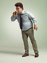 Image showing Man, obesity and drinking with beer for alcohol, belly or party on a studio background. Male person or plus size model with keg, glass or mug for beverage, wine or unhealthy drink on mockup space