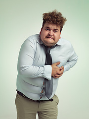 Image showing Man, portrait and plus size with heart attack, cardiac arrest or ache on a studio background. Frustrated male person or big model with body pain or cholesterol in unhealthy weight on mockup space