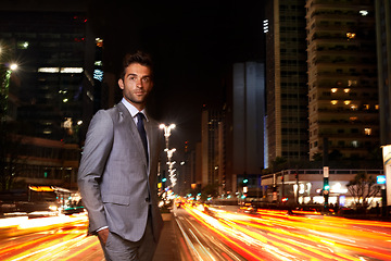 Image showing Businessman, portrait and city lights at night with traffic as financial advisor for corporate professional, building or late. Male person, face and suit with motion blur on urban, street or commute