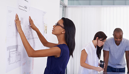 Image showing Woman, architect and planning with board of documents or paperwork in meeting for architectural design at office. Female person, contractor or designer with team for floor plan or ideas at workplace