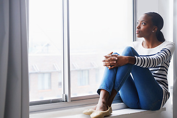 Image showing Woman, relax and thinking by window in new home with confidence for real estate investment and mortgage. African homeowner, person and thoughtful with future house ideas and relocation in living room