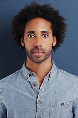 Image showing Young man, portrait or confident in studio as creative professional or casual fashion by blue background. Brazil person, face and afro for ambition as designer and trendy clothes or relax in closeup