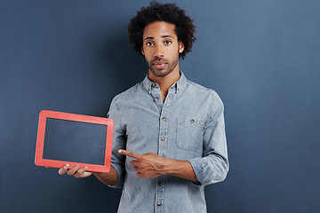 Image showing Blackboard, portrait and man with hand pointing to mockup in studio for news announcement on grey background. Frame, presentation or face of male model show space for promotion, info or sign up guide