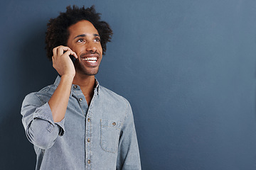 Image showing Man, phone call and communication in studio for talking connection on blue background for chat, networking or smile. Male person, cellphone and mockup space for connectivity, contact us or discussion