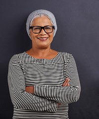 Image showing Portrait, old woman and fashion with glasses, arms crossed and happiness on dark studio background. Face, old person and model with confidence and eyewear with clear vision, hipster or stylish outfit