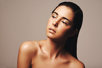Image showing Woman, makeup and gold eyeshadow for beauty, cosmetology and glamour with cosmetics on beige background. Glitter on eyes, elegance and fashion model in studio, art or creativity with shimmer and glow
