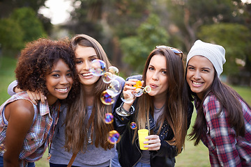 Image showing Friends, bubbles and portrait of women in nature for bonding, smile and happiness outdoors. Happy, fashion and gen z with people with soap bubble in park for weekend, holiday and vacation together