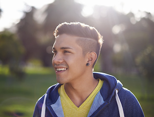 Image showing Smile, happy and young man outdoor in nature, environment and park to relax on break with closeup. Male person, student gen z guy and student enjoying summer outside by trees, grass and lens flare