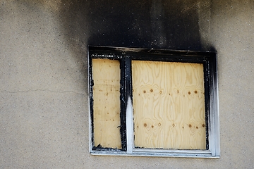 Image showing window boarded up with plywood after a fire