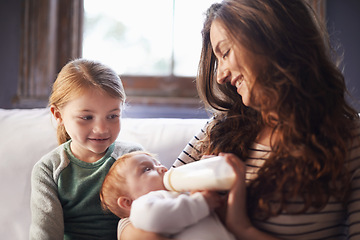 Image showing Mother, baby and milk feeding with child in a family home with love, support and care together. Smile, relax and bottle for youth development and growth with mom and young girl on a living room sofa