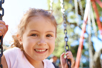 Image showing Girl, child and portrait on swing for playing in park with happiness, wellness and outdoor in South Africa. Kid, face and smile on playground for recreation, healthy childhood development and freedom