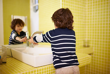 Image showing Boy, bathroom and hands with washing, hygiene and cleaning with mirror at home. Child, faucet and reflection for healthy, development and childhood with morning routine at home for cleanliness