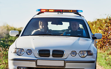 Image showing Policeman, car and drive in field to search at crime scene or robbery, safety and law enforcement for evidence. Detective, investigation and uniform in outdoor working at countryside with gravel road