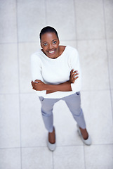 Image showing High angle, portrait and happy woman with arms crossed in business or office with confidence and pride. African, employee and above person in lobby excited for morning in workplace in London