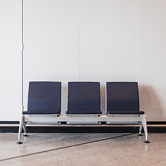 Image showing Rectangular chairs lined up against white wall in waiting room