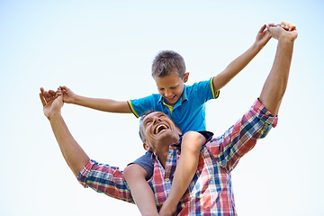 Image showing Smile, young boy and shoulders of father, sky and outdoors in park with happy. Laugh, love or bonding with son and dad with family, spring or carrying his child in summer and spending time together