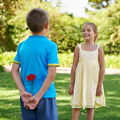 Image showing Children, smile and flower in park with surprise for crush, gift or friendship for spring and childhood on grass with tree. Little girl and boy with happiness and plant behind back for and joy