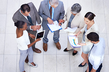 Image showing Documents, tablet and business people in meeting in lobby of office in collaboration. Paperwork, digital technology and high angle of professional financial advisors in discussion for teamwork.