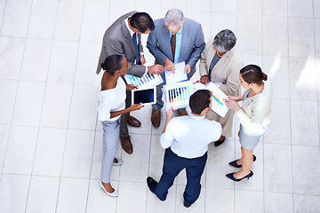 Image showing Paperwork, tablet and business people in discussion in lobby of office in collaboration. Documents, digital technology and high angle of professional financial advisors in meeting for teamwork.