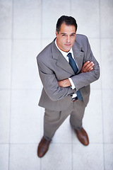 Image showing Man, portrait and high angle with arms crossed in business or office with professional confidence and pride. Above, entrepreneur and person in lobby to start morning in London at corporate workplace