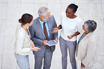 Image showing Discussion, tablet and business people in lobby of office in collaboration for finance project. Meeting, digital technology and high angle of professional financial advisors working on project.