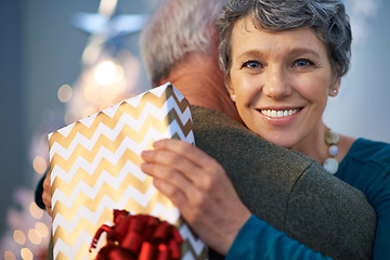 Image showing Christmas, gift and senior couple with love, hug and gratitude for holiday surprise, celebration and tradition at night. Portrait of elderly woman by bokeh lights with present pr thanksgiving at home