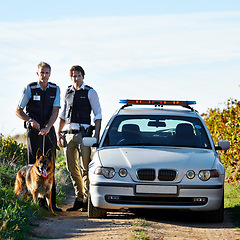 Image showing Policeman, dog and car in field to search at crime scene or robbery for safety, law enforcement and evidence. Detective, investigation and uniform in outdoor working at countryside with gravel road