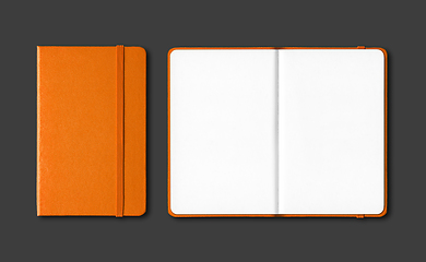 Image showing Orange closed and open notebooks isolated on black