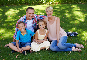 Image showing Happy, portrait and family in garden of home with love and gratitude for parents and children. Mother, father and kids smile in backyard on holiday or vacation in summer and relax together on grass