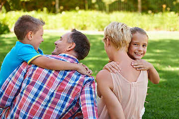 Image showing Mother, father and children hug in garden for family bonding on travel holiday in park for relax, connection or happy. Man, woman and siblings with back on backyard grass in Australia, summer or calm