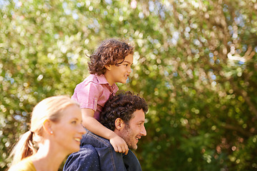 Image showing Piggyback, parents and child in nature on shoulder, happy care and bonding with kid smile in park. People, outside walking and family together in summer, love and growth for children development